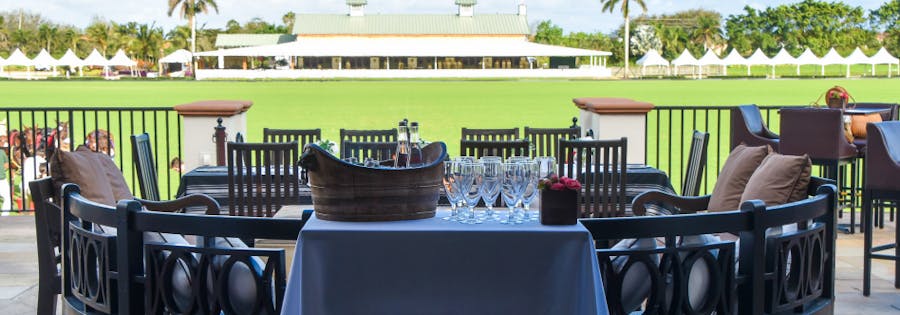 Elegant dining setup at the Polo Club with polo grounds view